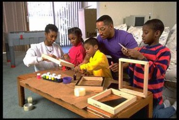 African American family make Kwanzaa gifts at home.